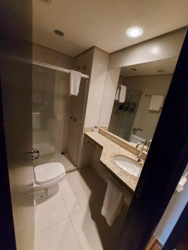 a bathroom with a toilet and a sink and a shower at Class Hotel Passos in Passos