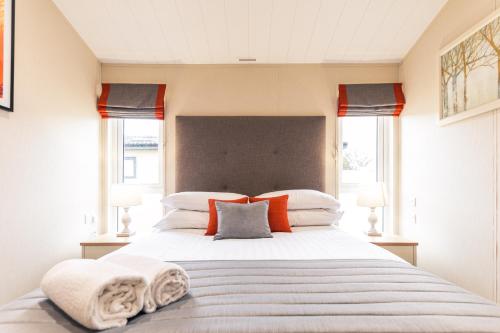 a bedroom with a large bed with towels on it at Heathery Lodge with Hot Tub in York