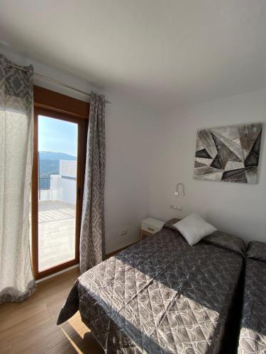 a bedroom with a bed and a large window at Casa con vistas 2 in Frigiliana