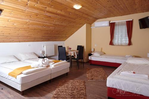 a large room with two beds and a table at Kamarás Klastrom House in Mogyoród