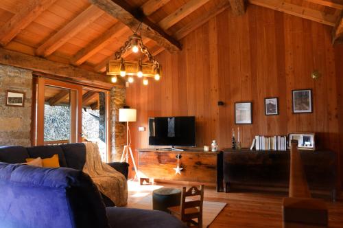 sala de estar con sofá y TV en LA MURA’ - Il vostro posto nel Gran Paradiso en Ronco Canavese