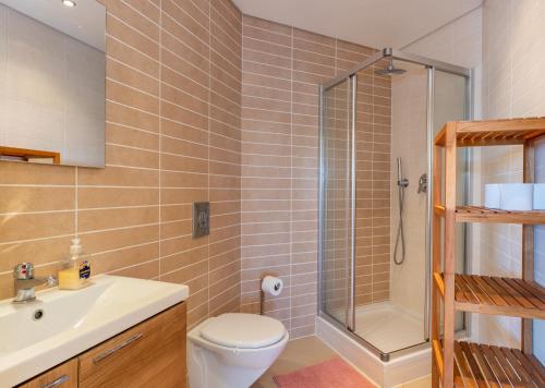 a bathroom with a shower and a toilet and a sink at Casa Laranja, Aromas Burgau in Burgau