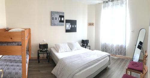 une chambre blanche avec un lit et une grande fenêtre dans l'établissement Gîtes tout confort Saujon, à Saujon