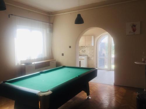 a pool table in a room with an arched doorway at Várhegy Vendégház in Fonyód