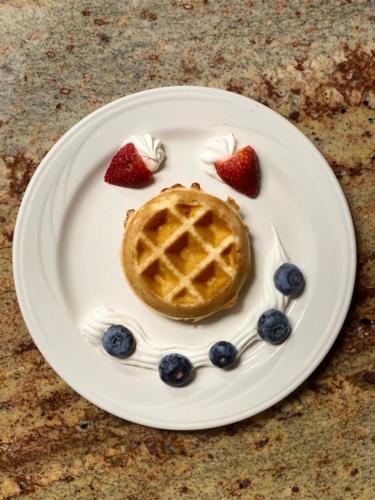 a waffle with strawberries and blueberries on a plate at Holiday Inn Lafayette North by IHG in Lafayette