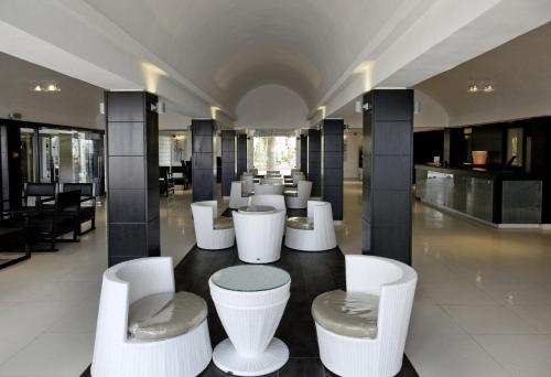 a group of white chairs and tables in a building at Samira Club Family and couples only in Hammamet