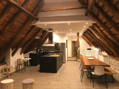 une cuisine et une salle à manger avec une table et des chaises en bois dans l'établissement Les Granges de Clarabide, à Loudenvielle