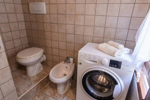bagno con lavatrice e servizi igienici di Miguel House ad Alghero