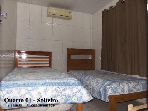 a bedroom with two beds and a window at Pedacinho do Toque in São Miguel dos Milagres