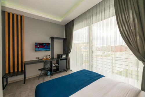 Un dormitorio con una cama y una ventana grande. en Melanj Airport Hotel, en Arnavutköy