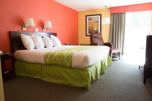a hotel room with a large bed with orange walls at The Tidewater Inn - Cape Cod in West Yarmouth