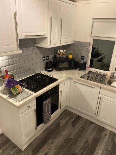 a kitchen with white cabinets and a stove top oven at The Lunar Ray in Felton
