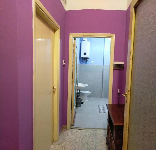 a bathroom with a purple wall and a toilet at traivicolidifoligno in Foligno