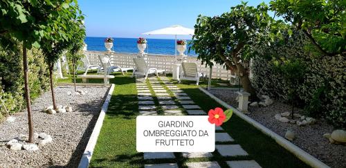 a sign in front of the beach with chairs and the ocean at Casa Genny in Nettuno
