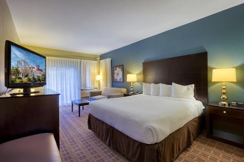 a hotel room with a bed and a flat screen tv at La Cuesta Inn in San Luis Obispo