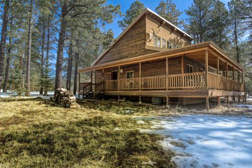 a log cabin in the woods with snow on the ground at Wait for it Getaway in Angel Fire