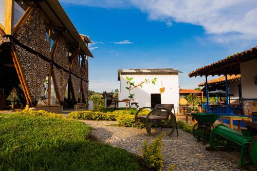 un jardin avec des bancs et un bâtiment avec un ciel bleu dans l'établissement Riverside Ecoliving Space, à Jericó