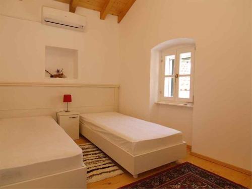 a bedroom with two beds and a window at Apartments in Veli Losinj 14994 in Veli Lošinj
