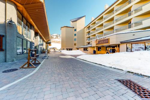 a cobblestone street with snow on the side of a building at Emmons Escape & Cozy Slopeside Condo in Crested Butte