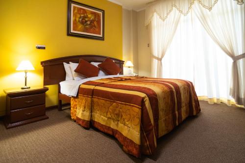 Un dormitorio con una cama grande y una ventana en Hotel Sierra Dorada en Ayacucho