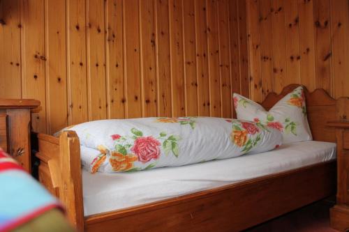 a bed in a wooden room with two pillows on it at Hotel Zur Erholung in Braunlage