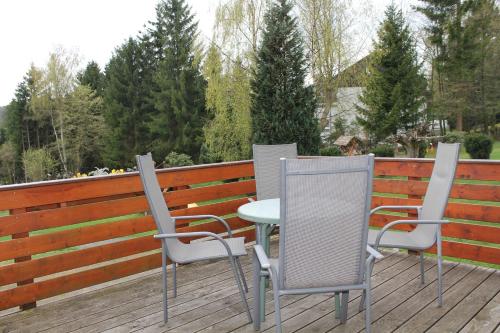 three chairs and a table on a deck at Hotel Zur Erholung in Braunlage