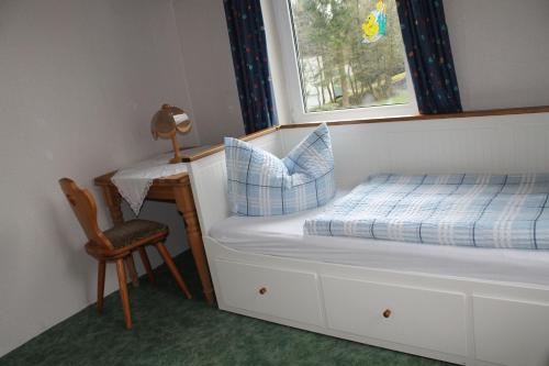 a bedroom with a bed and a desk and a window at Hotel Zur Erholung in Braunlage