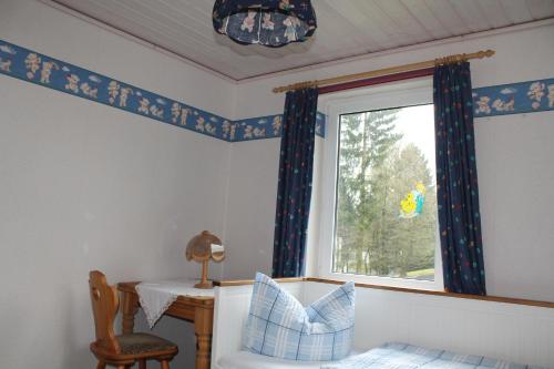a room with a window and a chair and a table at Hotel Zur Erholung in Braunlage