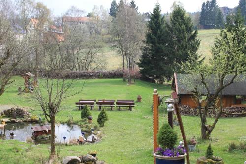 a park with benches and a pond and a house at Hotel Zur Erholung in Braunlage