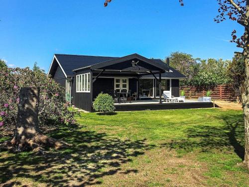 une maison avec un toit noir et une cour dans l'établissement Holiday home Struer III, à Struer