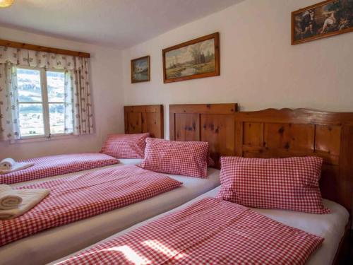 three beds in a room with red and white checks at Holiday home in Mühlbach im Pinzgau 35597 in Bicheln