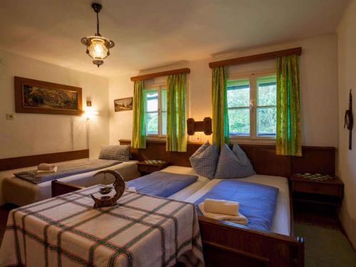 two beds in a bedroom with green curtains at Holiday home in Mühlbach im Pinzgau 35597 in Bicheln