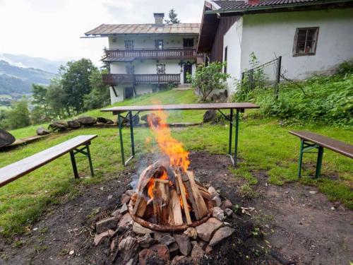 a fire pit in a yard with two benches at Holiday home in Mühlbach im Pinzgau 35597 in Bicheln