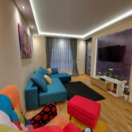 a living room with a couch and a tv at SunStone Apartment in Zlatibor