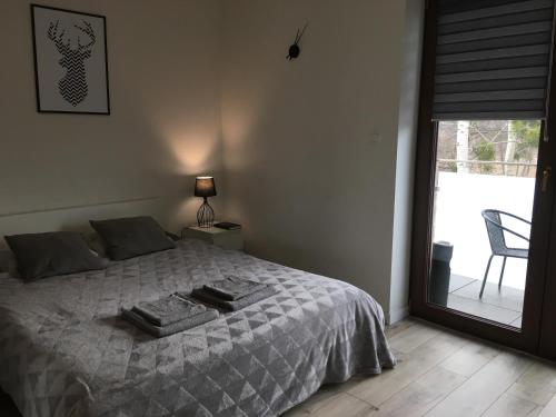 a bedroom with a bed and a chair and a window at Studio Fibra Barista in Rybnik