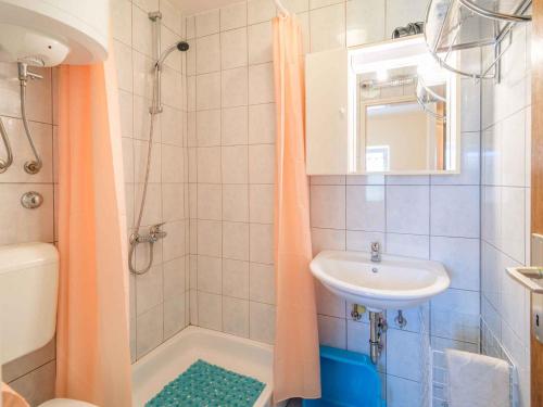 a bathroom with an orange shower curtain and a sink at Apartment in Vrbnik/Insel Krk 13614 in Vrbnik