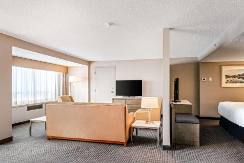 a hotel room with a bed and a couch at Best Western Premier Calgary Plaza Hotel & Conference Centre in Calgary