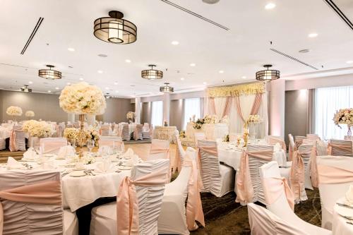 a banquet hall with white tables and chairs at Best Western Premier Calgary Plaza Hotel & Conference Centre in Calgary