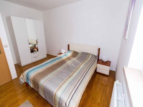 a bedroom with a large bed and a mirror at Apartment in Njivice/Insel Krk 27658 in Njivice