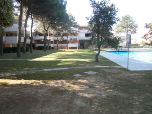 比比翁的住宿－Apartment in Bibione 24636，一座建筑和一个树木及建筑物的游泳池