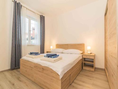 a bedroom with a large bed and a window at Apartments in Njivice/Insel Krk 27657 in Njivice