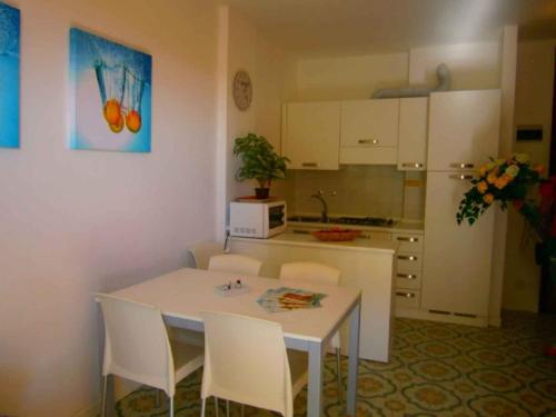 ビビオーネにあるApartment in Bibione 24633のキッチン(白いテーブル、椅子付)