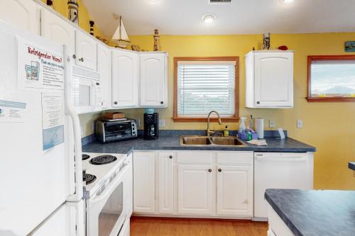 a kitchen with white cabinets and a white refrigerator at Slow M'Ocean #7-HH in Hatteras