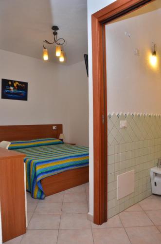 a bedroom with a bed and a shower at Domo - Guest-House Il Nespolo Fiorito in Orosei