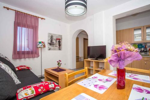 a living room with a table with a vase of flowers at Apartment in Njivice/Insel Krk 13321 in Njivice