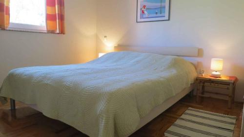 1 dormitorio con 1 cama blanca y 2 mesitas de noche en Apartment in Malinska/Insel Krk 13156, en Malinska