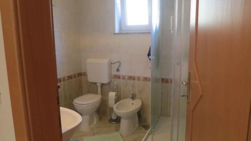 Baño pequeño con aseo y lavamanos en Apartment in Malinska/Insel Krk 13156, en Malinska