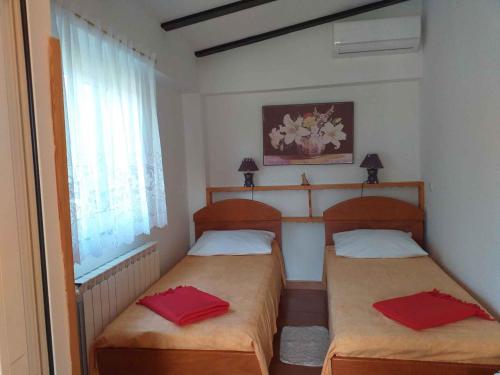 two beds in a small room with red pillows at Holiday home in Rovinj/Istrien 11494 in Kokuletovica