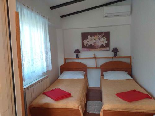 2 łóżka w małym pokoju z czerwonymi poduszkami w obiekcie Holiday home in Rovinj - Istrien 11494 w Rovinj