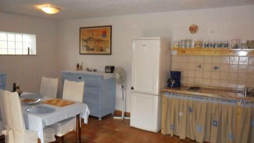a kitchen with a table and a white refrigerator at Holiday home in Rovinj/Istrien 11523 in Kokuletovica